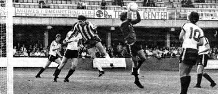 Hereford's Tommy Hughes cuts out a cross aimed at Peter Houghton